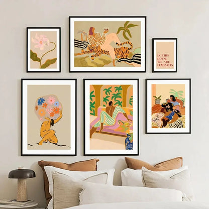 Set of framed artworks on a wall above a sofa with pillows.